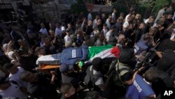 Militan Palestina membawa jenazah Shireen Abu Akleh, seorang jurnalis Al Jazeera, di kota Jenin, Tepi Barat. (Foto: AP)