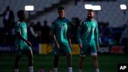 Real Madrid's Vinicius Junior, left, Real Madrid's Eder Militao, center, and Real Madrid's Karim Benzema gesture during a training session.