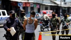 Policías y soldados escoltan a un joven a un centro de detención en San Salvador, El Salvador, el 2 de mayo de 2022.