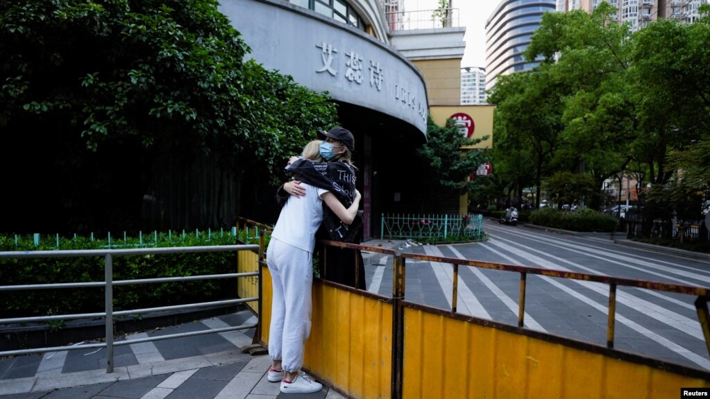 上海封城期间两名女子在一条被封的街道上拥抱。（2022年5月16日）(photo:VOA)