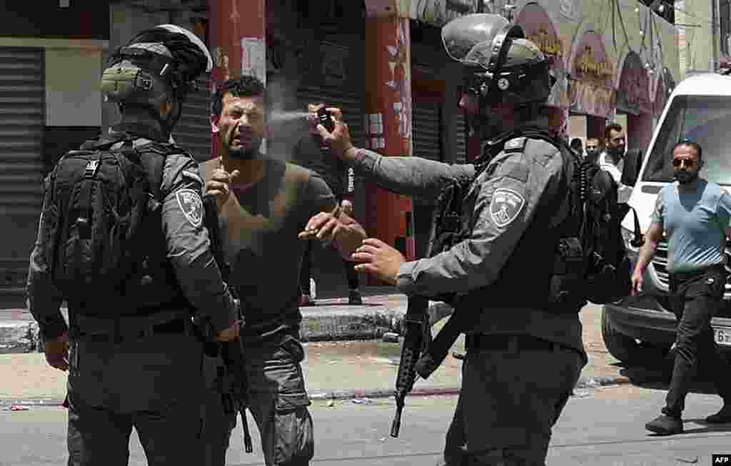 An Israeli border guard sprays pepper gas in the face of a Palestinian protester, during scuffles in the West Bank town of Hauwara.