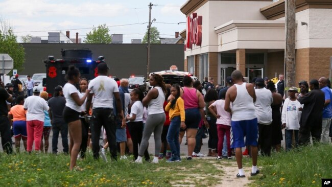 A crowd gathers as police investigate after a shooting at a supermarket, May 14, 2022, in Buffalo, N.Y.