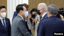 조 바이든(가운데 오른쪽) 미국 대통령이 20일 한국 평택에 있는 삼성전자 반도체 공장에서 윤석열(가운데 왼쪽) 한국 대통령과 악수하고 있다.