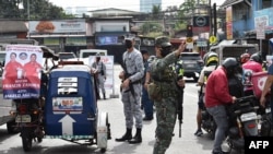 菲律宾军人与警察在马尼拉郊区的一个城镇检查站执勤。（2022年2月7日）