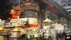 FILE - Workers on the job at a steel factory in Mariupol, southeast of Kyiv, Ukraine, Oct. 30, 2008. 