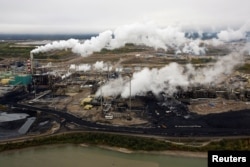 FILE - A Suncor tar sands processing plant stands near the Athabasca River at the company's mining operations near Fort McMurray, Alberta, Canada, Sept. 17, 2014.S