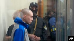 러시아 육군 바딤 쉬시마린 병장이 13일 우크라이나 수도 크이우(러시아명 키예프) 지방법원 내 유리로 분리된 공간에서 전범 혐의 심리에 참석하고 있다.