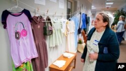 Darlene Shirk looks at the clothes of sexual assault survivors from Amish, Mennonite and other plain-dressing religious groups on display at a child abuse prevention seminar, on April 29, 2022, in Leola, Pa.