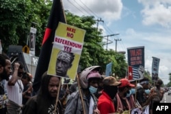 Mahasiswa Papua menggelar unjuk rasa menentang rencana pemerintah Indonesia untuk mengembangkan wilayah administrasi baru di Papua, di Surabaya pada 10 Mei 2022. (Foto: AFP/JUNI KRISWANTO)