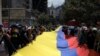 Los trabajadores llevan una larga pancarta que representa la bandera nacional colombiana durante una manifestación del Primero de Mayo para conmemorar el día internacional de los trabajadores, en Bogotá, el 1 de mayo de 2022. [Foto de Raul ARBOLEDA / AFP]