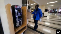 Foto ilustrasi yang menunjukkan seorang pekerja membersihkan area dekat telepon umum di arena pacuan kuda Pimlico di Baltimore, AS, pada 19 Mei 2022. (Foto: AP/Julio Cortez)