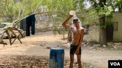 A young man has a mid-afternoon bath to cope with the severe heat that gripped India in recent weeks. (Anjana Pasricha/VOA)