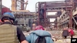 FILE - This frame taken from an undated video provided May 1, 2022, by the Azov Special Forces Regiment of the Ukrainian National Guard shows people walking over debris at the Azovstal steel plant, in Mariupol, eastern Ukraine. 