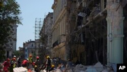 Trabajadores de emergencia caminan entre los escombros frente al Hotel Saratoga después de una explosión mortal en La Habana Vieja, Cuba, el viernes 6 de mayo de 2022.