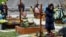 People pay respect next to graves at Lychakiv Cemetery where some people killed in Russia's invasion of Ukraine are buried as the Day of Heroes of the Heavenly Hundred is celebrated, in Lviv, Ukraine, May 22, 2022. 