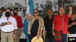 La presidenta de Honduras, Xiomara Castro (centro), y el presidente del Congreso Nacional, Luis Redondo (izquierda), saludan a los trabajadores durante la manifestación del Primero de Mayo (Día del Trabajo) en San Pedro Sula, Honduras, el 1 de mayo de 2022.