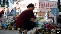 Una mujer en el sitio conmemorativo de las víctimas que murieron en el tiroteo en la Escuela Primaria Robb en Uvalde, Texas, el viernes 27 de mayo de 2022. (Foto AP/Dario Lopez-Mills)