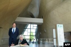 U.S. Treasury Secretary Janet Yellen accompanied by U.S. Ambassador to Poland Mark Brzezinski signs the visitors' book after her visit to the Polin Museum of Polish Jews History in Warsaw on May 16, 2022.