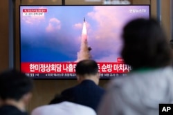 Orang-orang menonton program berita yang melaporkan peluncuran rudal Korea Utara, di sebuah stasiun kereta api di Seoul, Korea Selatan, 25 Mei 2022. (Foto: AP)