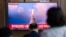 People watch a news program reporting about North Korea's missile launch with a file image, at a train station in Seoul, South Korea, May 25, 2022. Hours after U.S. President Joe Biden left Asia, North Korea launched three ballistic missiles toward the sea, its neighbors said.