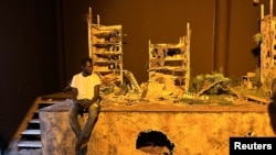 Senegalese artist Fally Sene Sow takes a rest next to his art installation during the 14th edition of the Dakar Biennale in Dakar, Senegal, May 19, 2022.