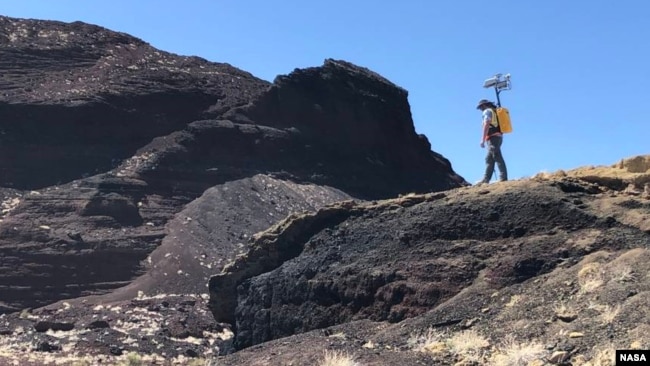NASA scientist Michael Zanetti explores the Cinder cone in Potrillo volcanic field in New Mexico in late 2021. Zanetti was testing a working model of NASA’s KNaCK device, a mobile LiDAR scanner now in development. (Photo Credits: NASA/Michael Zanetti)
