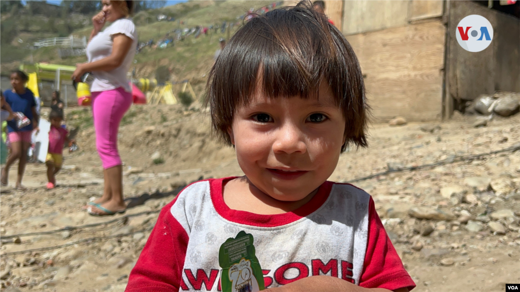 Un niño migrante guatemalteco sonríe tras mostrar el muñeco que le regalaron voluntarios que llegaron a repartir cosas para las familias migrantes que se han establecido en el Cañón del Alacrán, en Tijuana. Foto: Celia Mendoza, 9 de abril de 2022. Tijuana, México.