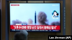 资料照片：人们在韩国首尔的一处火车站观看有关朝鲜发射导弹的资料镜头。(2022年5月12日)