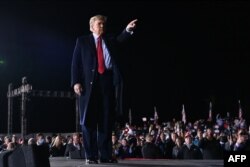 Presiden AS Donald Trump memberi isyarat setelah berbicara selama rapat umum untuk mendukung senator petahana Republik Kelly Loeffler dan David Perdue di Dalton, Georgia, pada 4 Januari 2021. (Foto: AFP)