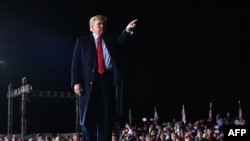 US President Donald Trump gestures after speaking during a rally in support of Republican incumbent senators Kelly Loeffler and David Perdue in Dalton, Georgia, on January 4, 2021.
