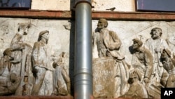 A bird sits at a bas-relief on an old Soviet-era clubhouse, depicting Soviet Union founder Vladimir Lenin speaking to workers in St. Petersburg, Russia, May 25, 2022.