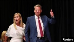 Gubernur Georgia Brian Kemp, merayakan kemenangan bersama istrinya, Marty Kemp, usai mengalahkan kandidat dukungan Donald Trump dalam pemilihan pendahuluan partai Republik hari Selasa (24/5). 