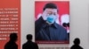 In this picture taken on January 15, 2021, a picture of China's President Xi Jinping with a face mask is displayed as people visit an exhibition about China's fight against the COVID-19 coronavirus.