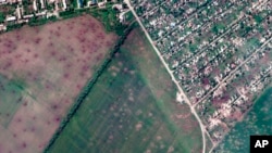 This satellite image provided by Maxar Technologies shows an overview of artillery craters in fields and destroyed buildings from recent artillery shelling, in Lyman, Ukraine, May 26, 2022.