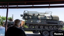 A local resident looks at a rocket launcher vehicle being transported, amid Russia's invasion of Ukraine, near Kramatorsk, Donetsk region, Ukraine, May 30, 2022.