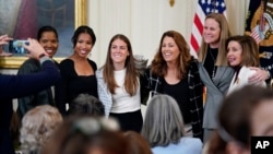 FILE - Former and current members of the US Women's National soccer team, Briana Scurry, Margaret Purce, Kelley O'Hara, Julie Foudy, and Cindy Parlow Cone, with House Speaker Nancy Pelosi, before an event to celebrate Equal Pay Day at the White House, March 15, 2022.