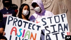 Sejumlah warga membawa poster berisi ajakan untuk menghentikan kebencian terhadap warga keturunan Asia di AS dalam sebuah aksi di Monumen Logan Square di Chicago, pada 20 Maret 2021. (Foto: AP/Nam Y. Huh)