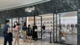 People wearing face masks line up outside a store of French luxury brand Celine, at a reopened shopping mall amid the COVID-19 outbreak in Shanghai, China, May 29, 2022.