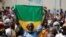Seorang pendukung dari presiden sementara Mali membawa bendera Mali dalam aksi unjuk rasa untuk mendukung kelompok Junta dan Rusia di Bamako, pada 13 Mei 2022. (Foto: AFP/Ousmane Makaveli)