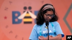 Harini Murali, 10 from Edison, New Jersey, spells out a word on her arm as she competes during the Scripps National Spelling Bee.