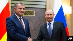 FILE - Russian President Vladimir Putin, right, and Anatoly Bibilov, president of Georgia's breakaway province of South Ossetia, shake hands during their meeting in Novo-Ogaryovo residence, outside Moscow, Russia, on Nov. 14, 2017. 