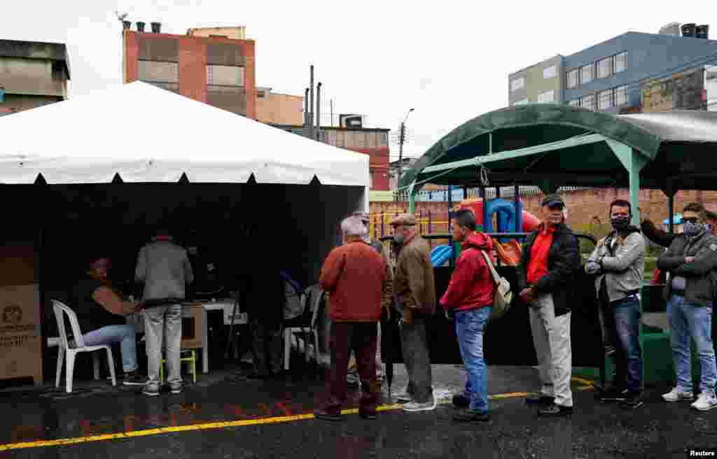 La gente espera en fila para emitir sus votos en un colegio electoral durante la primera vuelta de las elecciones presidenciales en Bogotá, Colombia, el 29 de mayo de 2022. REUTERS/Santiago Arcos