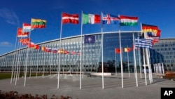 FILE - Flags flutter in the wind outside NATO headquarters in Brussels, Feb. 7, 2022. The Russian invasion has led historically neutral countries, like Sweden and Finland, looking to join NATO. (AP Photo/Olivier Matthys, File)