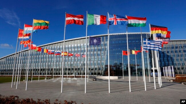FILE - Flags flutter in the wind outside NATO headquarters in Brussels, Feb. 7, 2022. The Russian invasion has led historically neutral countries, like Sweden and Finland, looking to join NATO. (AP Photo/Olivier Matthys, File)