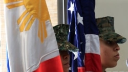 Anggota korps marinir Filipina-AS berdiri tegak dengan bendera Filipina dan Amerika di Kota Taguig, metro Manila, Filipina. (Foto: Reuters)