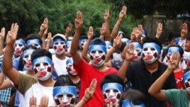 FILE - Young demonstrators flash the three-fingered symbol of resistance during an anti-coup mask strike in Yangon, Myanmar, April 4, 2021.