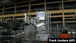 Personnel look up at an experimental salt-based heat storage facility at Berlin's Reuter thermal power station on Wednesday, April 24, 2019. The energy company, together with a Swedish start-up, is testing the use of salt to store heat, which accounts for