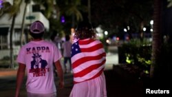 Beberapa mahasiswa berjalan-jalan di Pantai Miami setelah otoritas menutup restoran, bar, bioskop, gym dan bisnis serupa untuk pencegahan virus corona, Miami Beach, Florida, 18 Maret 2020. (Foto: Reuters)
