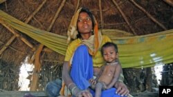 21-month-old Sushila, who weighs 4.5 kg and suffers from severe malnutrition, sits in her mother's lap in Kirwara village of Sheopur district in the central Indian state of Madhya Pradesh, April 2010 (file photo)