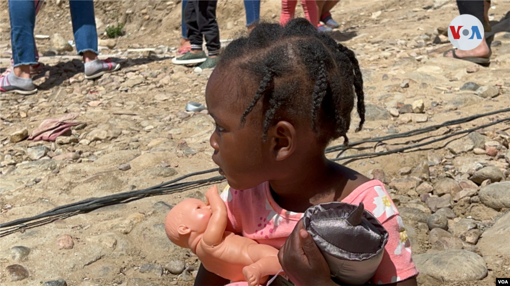 Una niña haitiana mira a la distancia en el Cañón del Alacrán, mientras voluntarios entregan comida y juguetes a los pequeños migrantes que han estado esperando en esta zona fronteriza hasta por dos años, a que se elimine el Título 42 y poder pedir asilo en Estados Unidos. Foto: Celia Mendoza, 9 de abril de 2022. Tijuana, México.